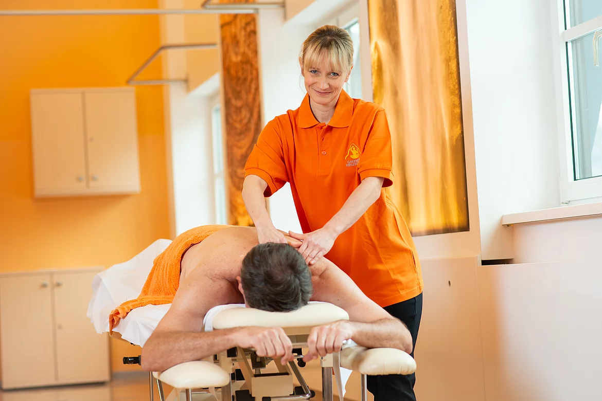 Der Patient wird von der Therapeutin am Rücken massiert