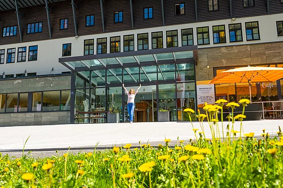 Patientin geht aus dem Gasteiner Heilstollen und hebt die Hände in die Höhe.