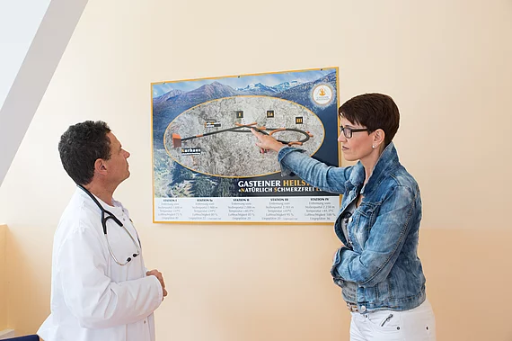 Gasteiner Heilstollen Patientin mit Fibromyalgie bei ihrer Voruntersuchung beim Arzt. Erklaerung des Heilstollens an einem Querschnitt-Bild.