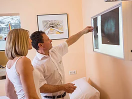 Patientin betrachtet mit Arzt Roentgenbild im Gasteiner Heilstollen.