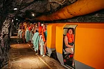 Patientin mit Morbus Bechterew sitzt im Zug im Gasteiner Heilstollen, Patienten steigen aus.