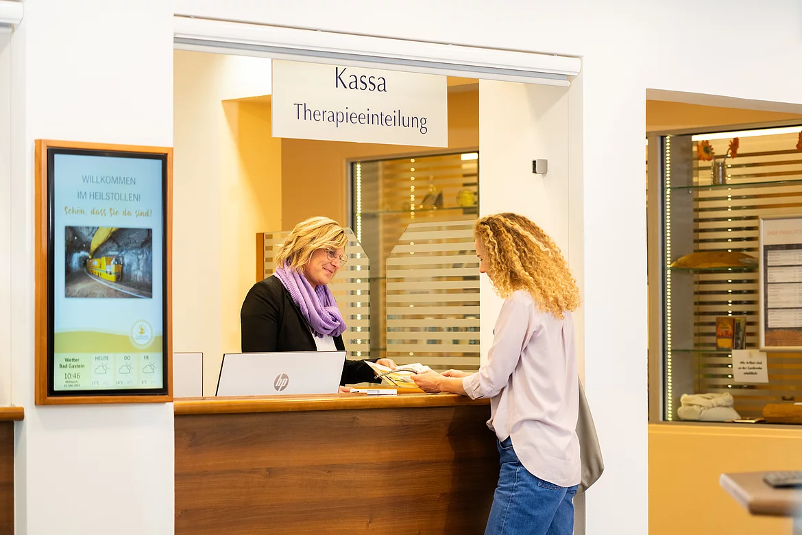 Frau wird von Mitarbeiterin empfangen und bekommt alle Informationen und wird für die Therapie eingeteilt