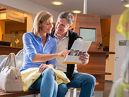 Mann und Frau lesen die Informationszeitschrift des Gasteiner Heilstollen