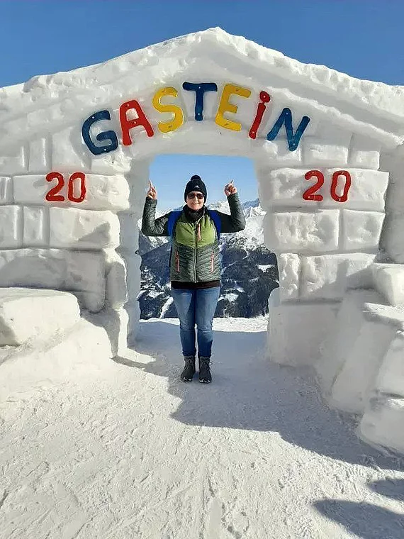 Heilstollen Patientin mit Chronischer Polyarthritis steht vor einem Schneekunstwerk in Gastein.