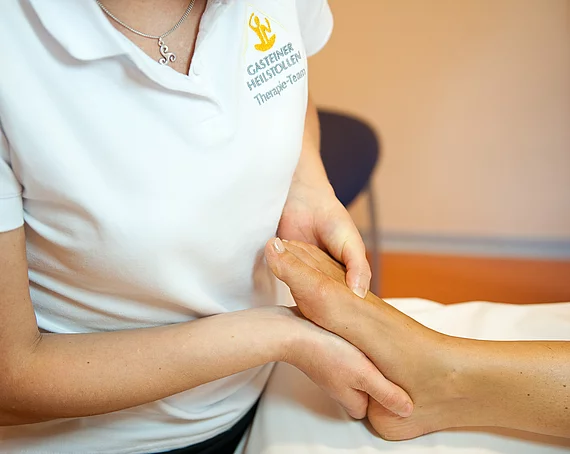Therapeutin macht Fussreflexzonenmassage im Gasteiner Heilstollen.