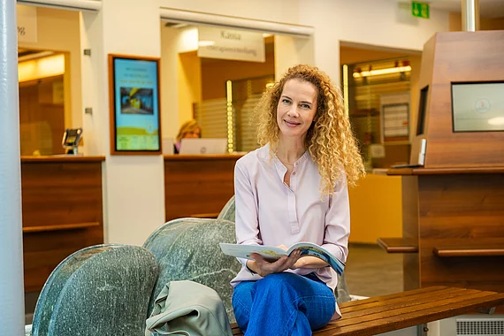 Frau liest Informationen in dem Gasteiner Heilstollen Magazin