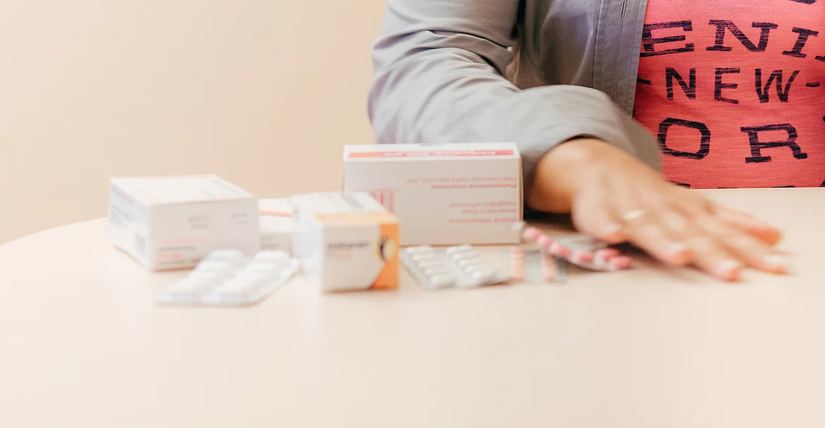 Patientin mit Fibromyalgie wischt Medikamente weg.