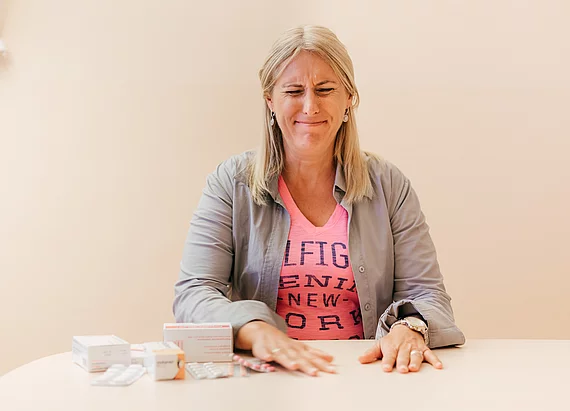 Patientin mit Fibromyalgie wischt Medikamente weg.
