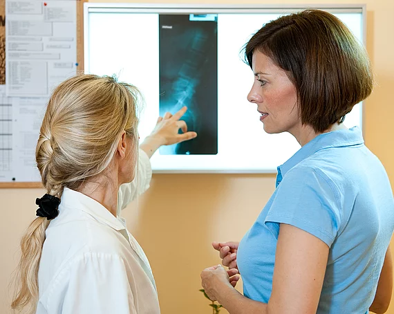 Ärztin bespricht mit Patientin das Röntgenbild im Gasteiner Heilstollen.