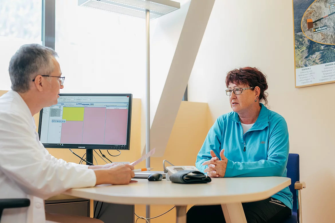 Patientin mit Morbus Bechterew bespricht sich mit einem Arzt im Gasteiner Heilstollen.