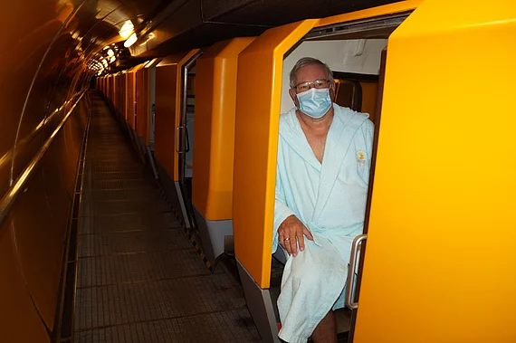 Patient mit Morbus Bechterew im Zugabteil im Gasteiner Heilstollen während Corona.