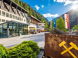 Haupteingang des Gasteiner Heilstollens mit einem Bergwerkswagen vorne im Bild