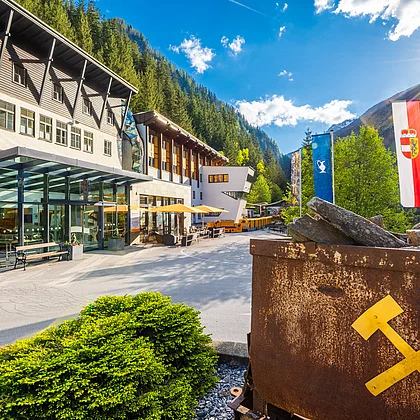 Haupteingang des Gasteiner Heilstollens mit einem Bergwerkswagen vorne im Bild