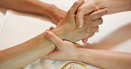 Hände bei der Therapie im Gasteiner Heilstollen.