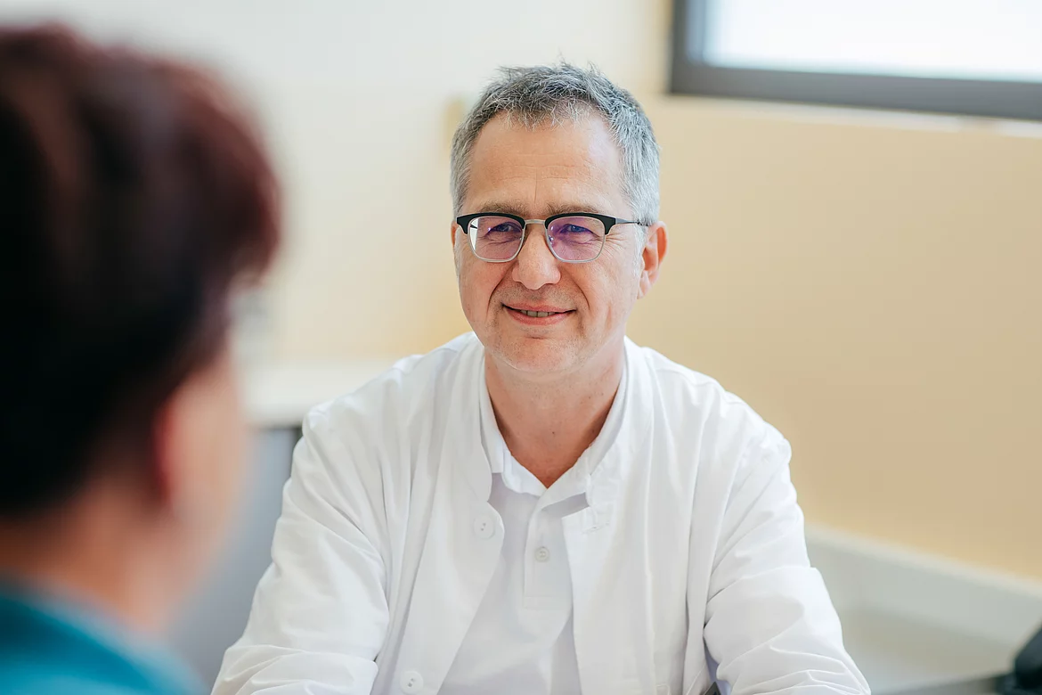 Patientin mit Morbus Bechterew bespricht sich mit einem Arzt im Gasteiner Heilstollen.