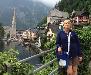 Patientin Gasteiner Heilstollen steht auf Brücke vor einer Ortschaft.