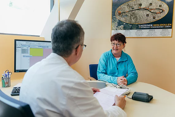 Patientin mit Morbus Bechterew bespricht sich mit einem Arzt im Gasteiner Heilstollen.