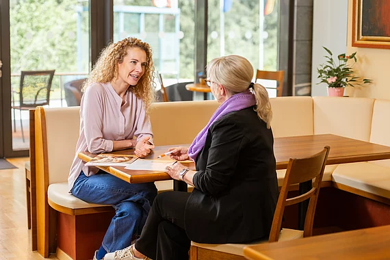 Patientin bespricht sich mit Mitarbeiterin Patientenservice im Heilstollen.