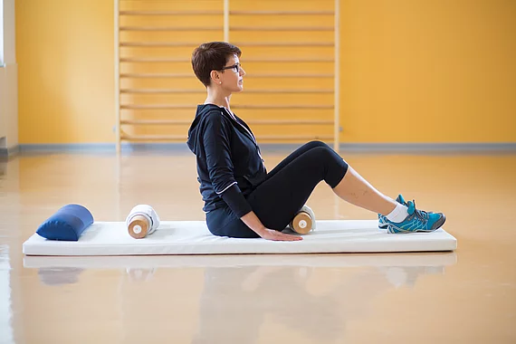 Gasteiner Heilstollen Patientin mit Fibromyalgie bei einer Physiotherapie mit Ball mit Rollenuebung
