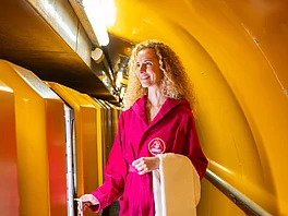 Die Patientin steht im Bademantel vorm Waggon des Heilstollen-Zugs